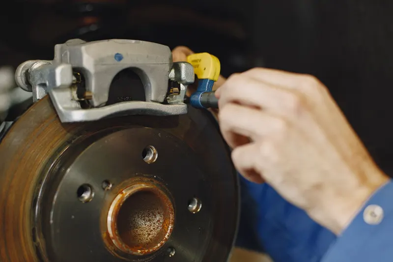 Close-up of a brake rotor and caliper being serviced