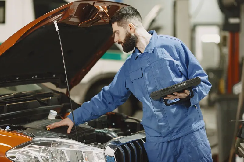 Technician running computer diagnostics on a vehicle